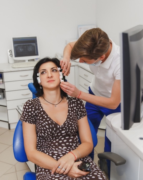 Woman having her jaw joints examined by a dentist