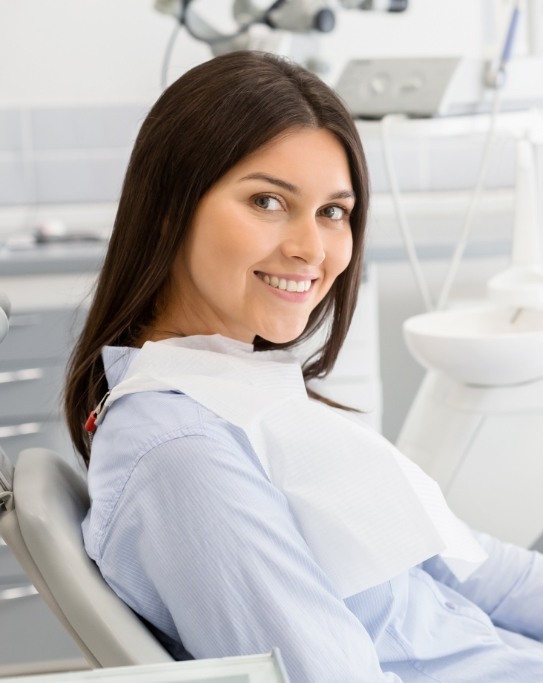 Smiling woman leaning back in dental chair