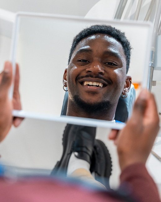 A man looking at his smile in the dentist’s office