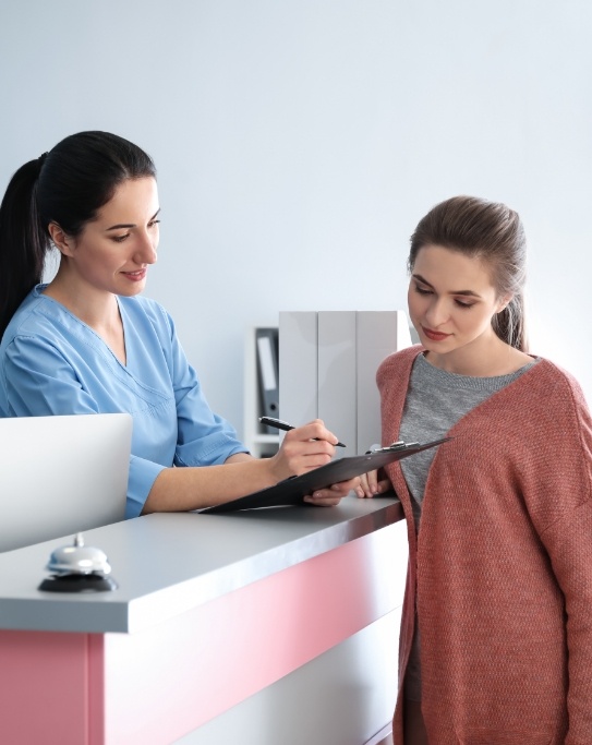 Dental team member showing a clipboard to a patient