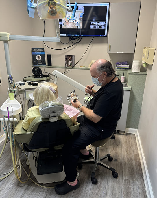 Dentist showing a dental implant model to a patient