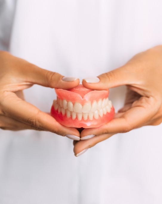 Dentist holding a set of full dentures