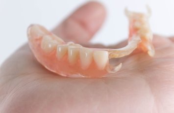 Hand holding a partial denture