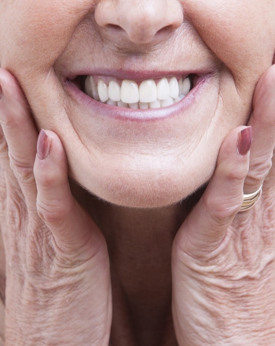 Smiling senior woman touching her face