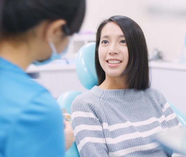 Woman in dental chair talking to her dentist