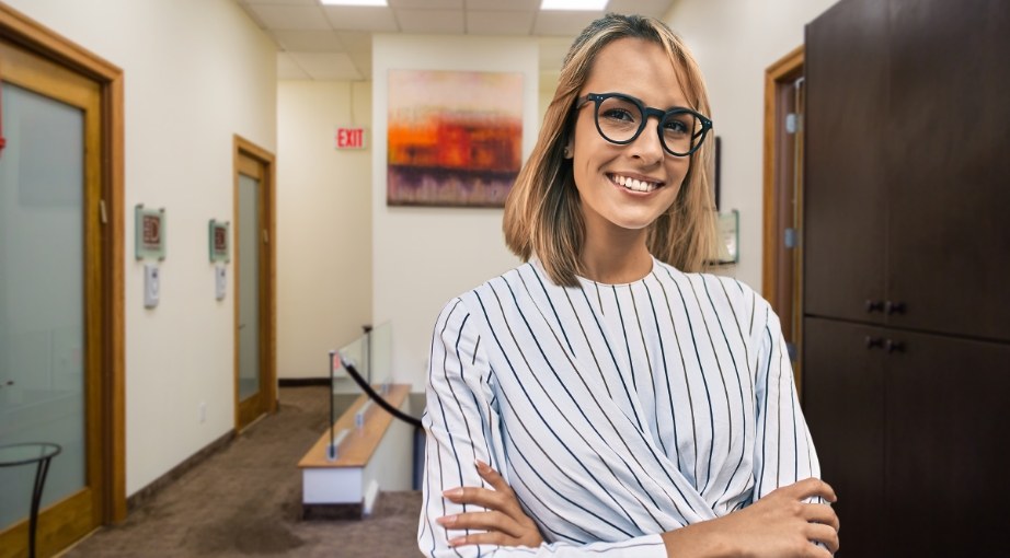 Woman smiling with her arms crossed in New York dental office