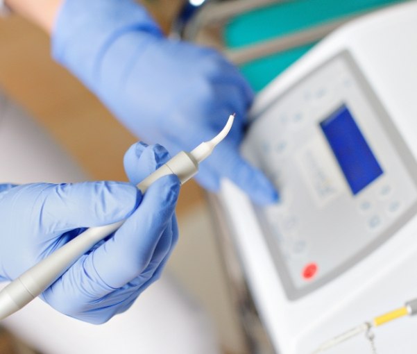 Gloved hand holding a dental laser in New York