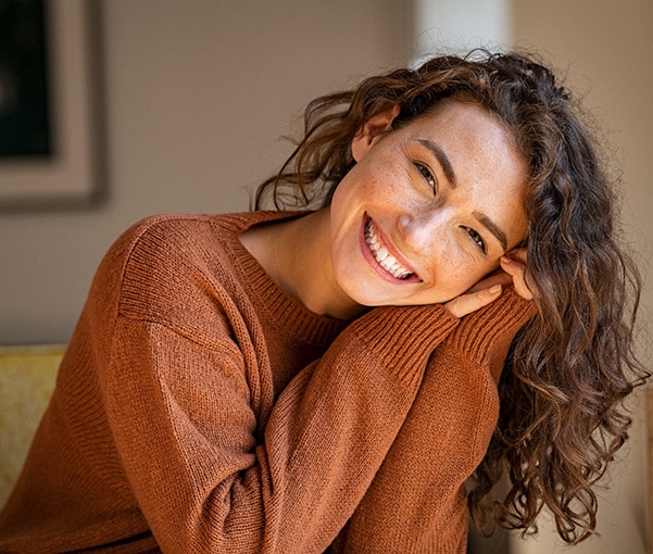 A young woman smiling while relaxing at home