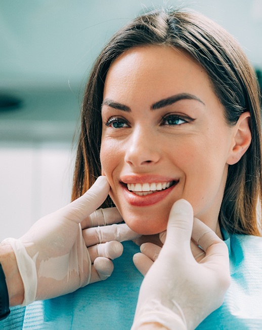 A dentist preparing a woman for a smile makeover