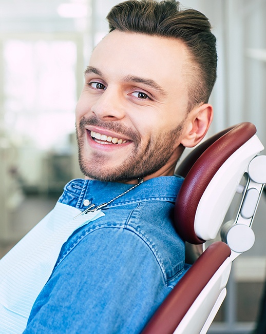 A happy, smiling man sitting in a dentist’s chair