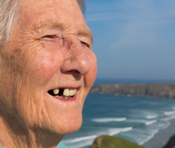 Senior on the beach with a missing upper tooth