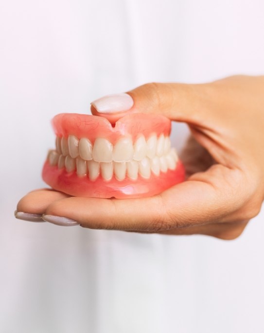 Dentist holding a set of full dentures