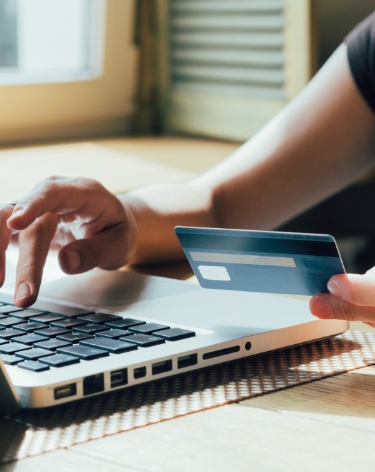 Person entering their credit card information on a laptop