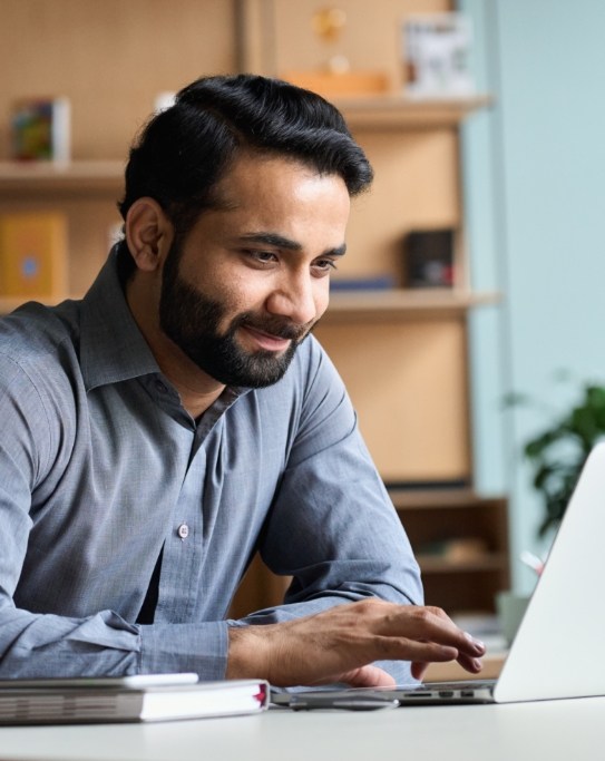 Man sitting at desk using laptop