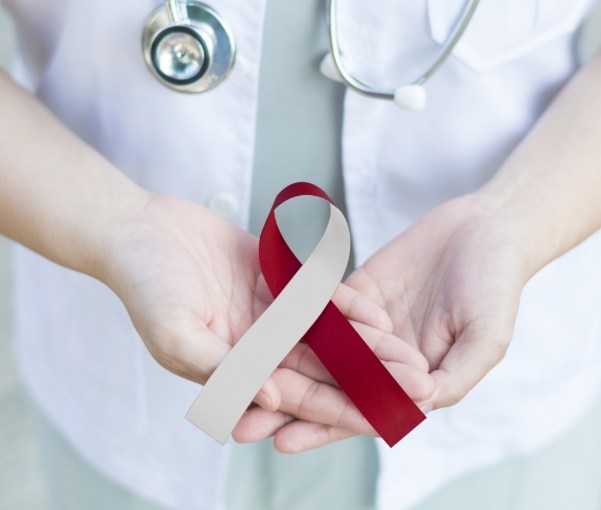 Medical professional holding a ribbon representing oral cancer