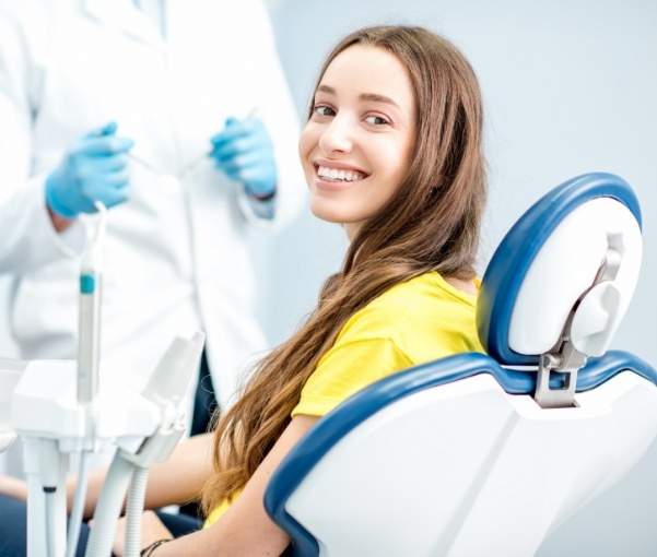 Woman in yellow blouse smiling during preventive dentistry checkup in New York