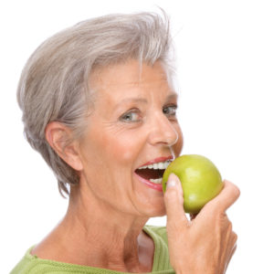 woman smiling biting into apple