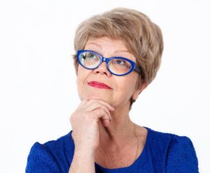 older woman thinking blue glasses