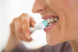 : Person with beautiful smile from a dentist in Gramercy Park brushing teeth