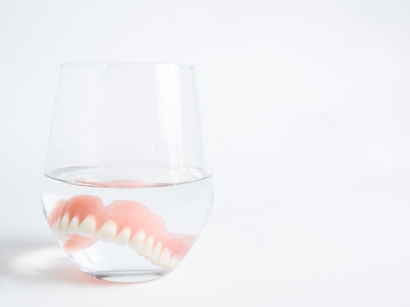 soaking dentures overnight in a glass cup