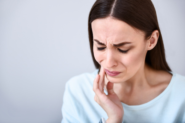 woman grimacing with jaw pain