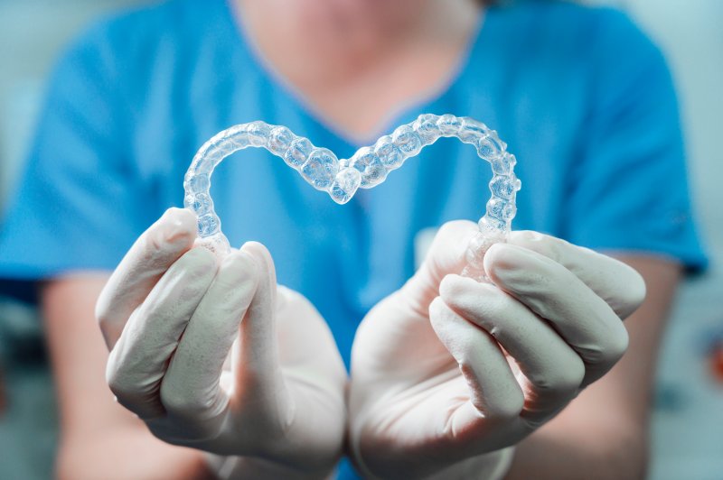 dentist making heart shape with aligners