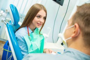 Woman in dental chair listening to dentist