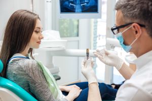 dentist showing a patient a dental implant