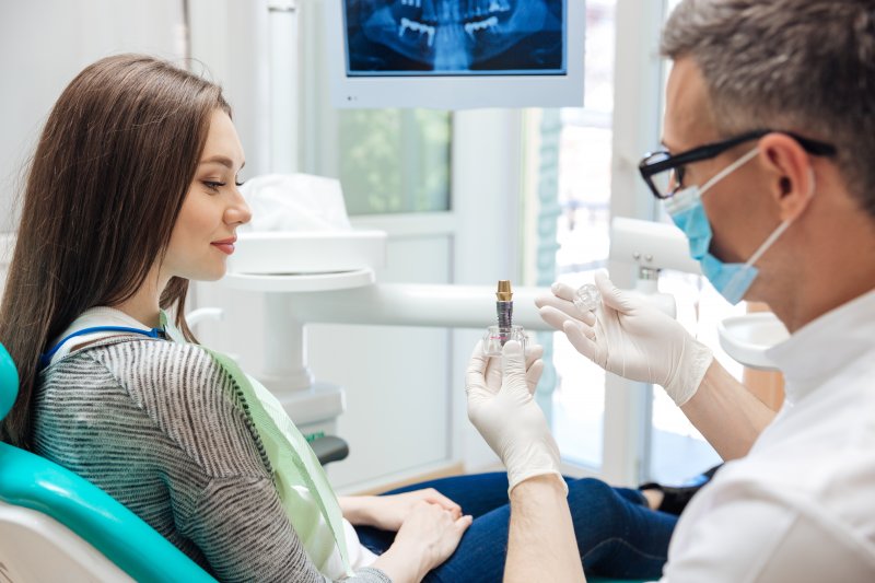 A dentist explaining a dental implant to a patient