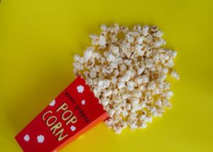 Knocked over box of popcorn on yellow background