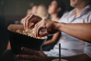 hands getting popcorn at the movies