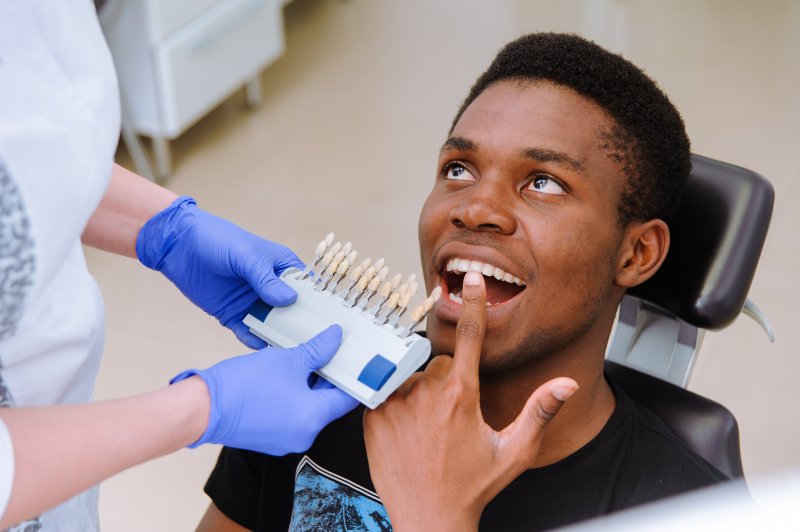 a patient pointing at his teeth during the smile makeover process